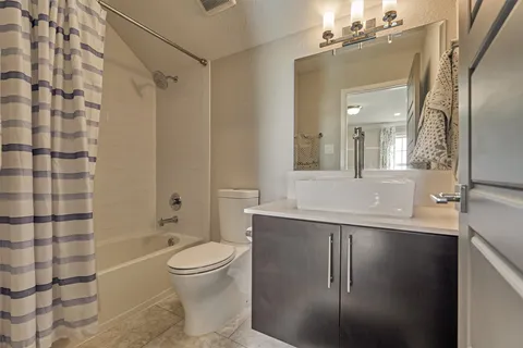 a bathroom with a sink a toilet and shower a mirror