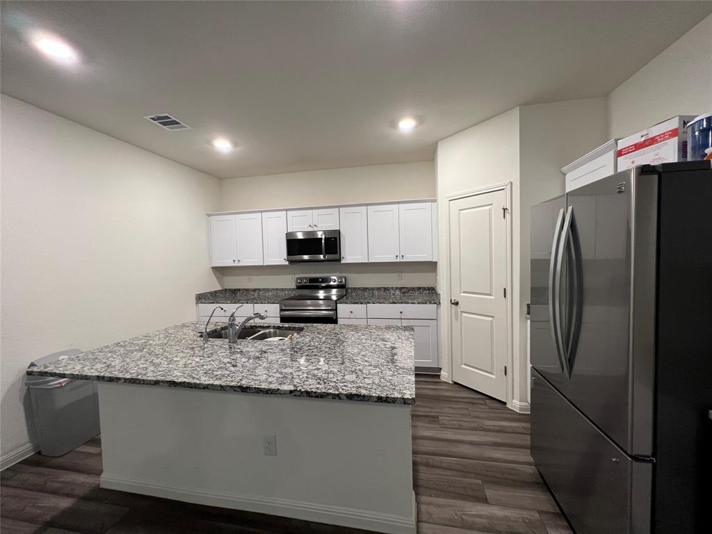 309 Redfish Lane Hutto, TX 78634 - Photo 3 of 15 a kitchen with stainless steel appliances granite countertop a refrigerator a stove and a sink