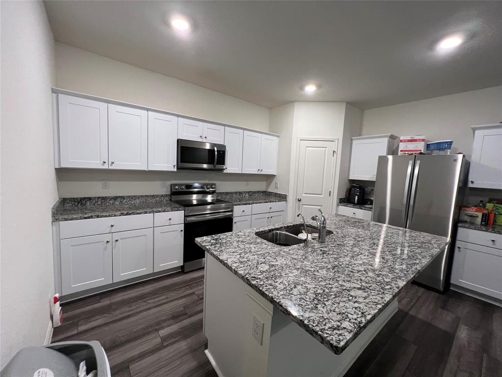 309 Redfish Lane Hutto, TX 78634 - Photo 4 of 15 a kitchen with kitchen island a counter space a sink appliances and cabinets