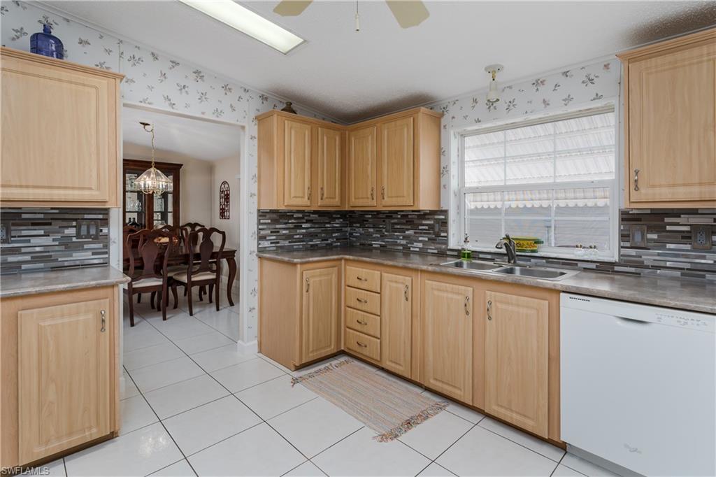 255 Riverwood Road Naples, FL 34114 - Photo 11 of 35 a kitchen with sink cabinets and window