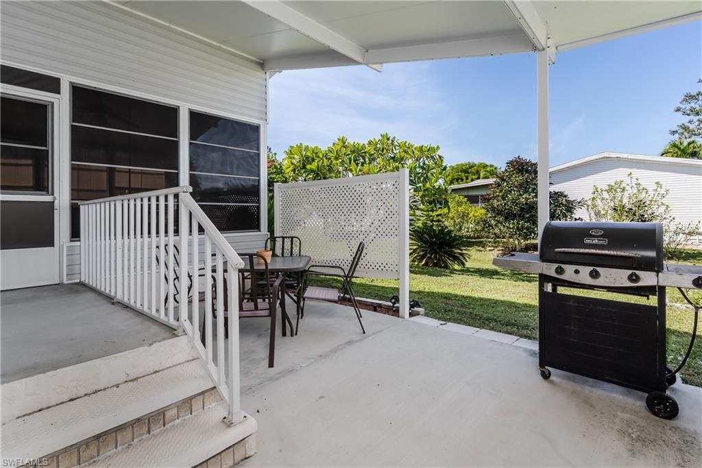 255 Riverwood Road Naples, FL 34114 - Photo 17 of 35 a view of a deck with table and chairs and potted plants
