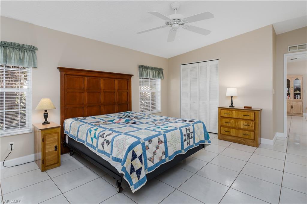 255 Riverwood Road Naples, FL 34114 - Photo 20 of 35 a bedroom with a bed and a chandelier