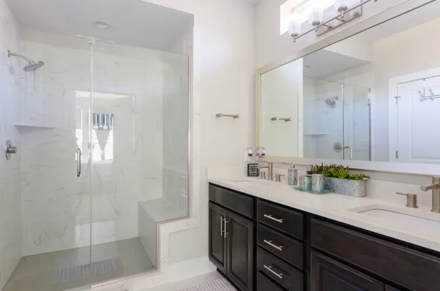 a bathroom with a sink double vanity granite tub and a mirror