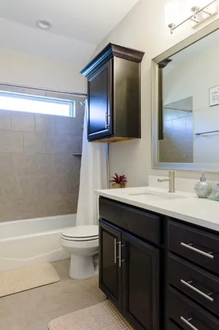 a bathroom with a granite countertop toilet sink and mirror
