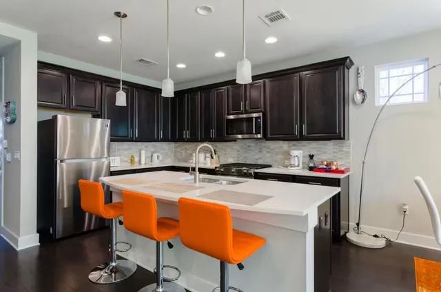 a kitchen with stainless steel appliances granite countertop a sink refrigerator and cabinets