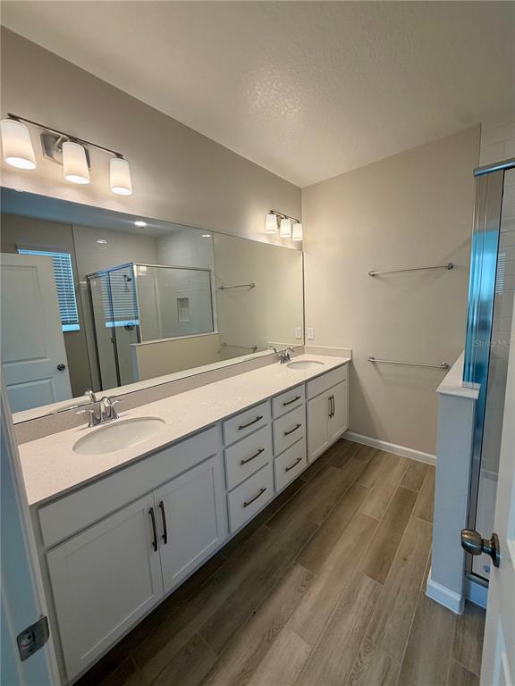 5222 Ctr Lk Rnch Boulevard St. Cloud, FL 34771 - Photo 21 of 25 a spacious bathroom with a double vanity sink a mirror and a shower