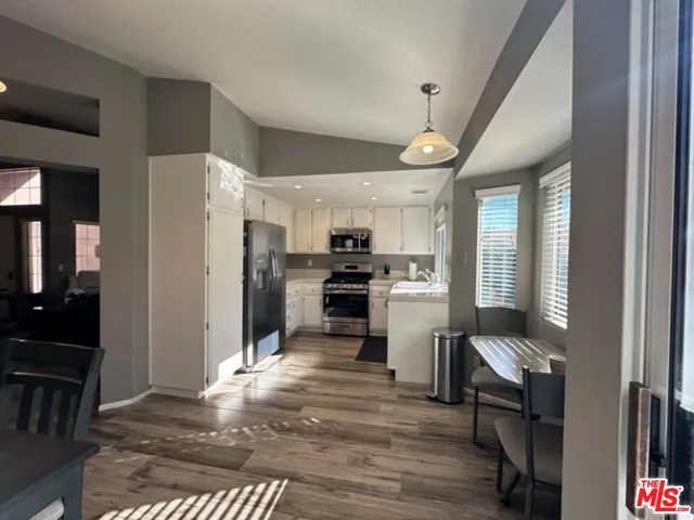 a kitchen with granite countertop a refrigerator stove top oven and sink