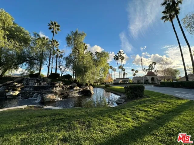 a view of a yard in front of a house with large trees