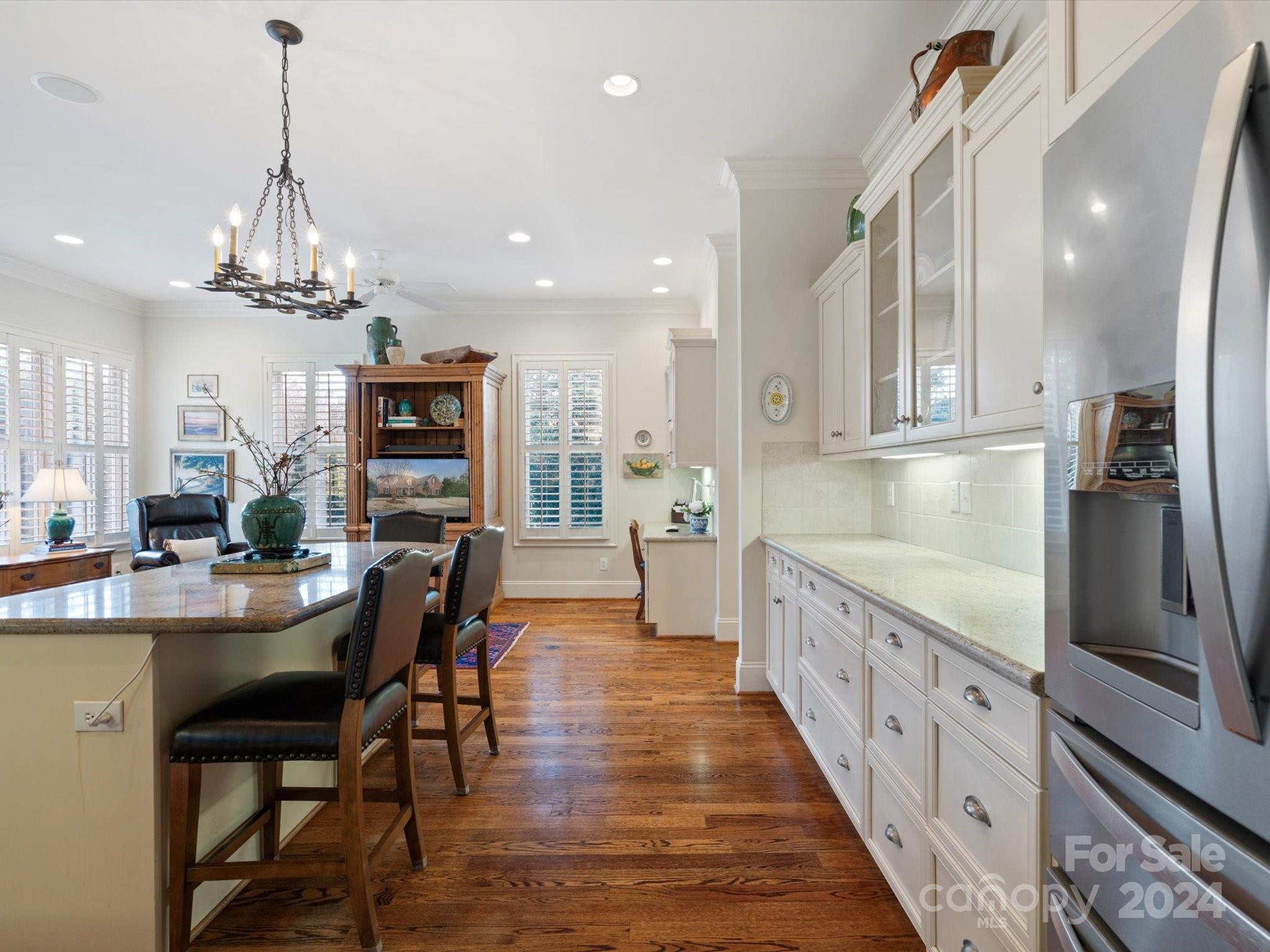 135 Spring Branch Road Fort Mill, SC 29715 - Photo 11 of 48 a kitchen with stainless steel appliances kitchen island granite countertop a table chairs and a refrigerator