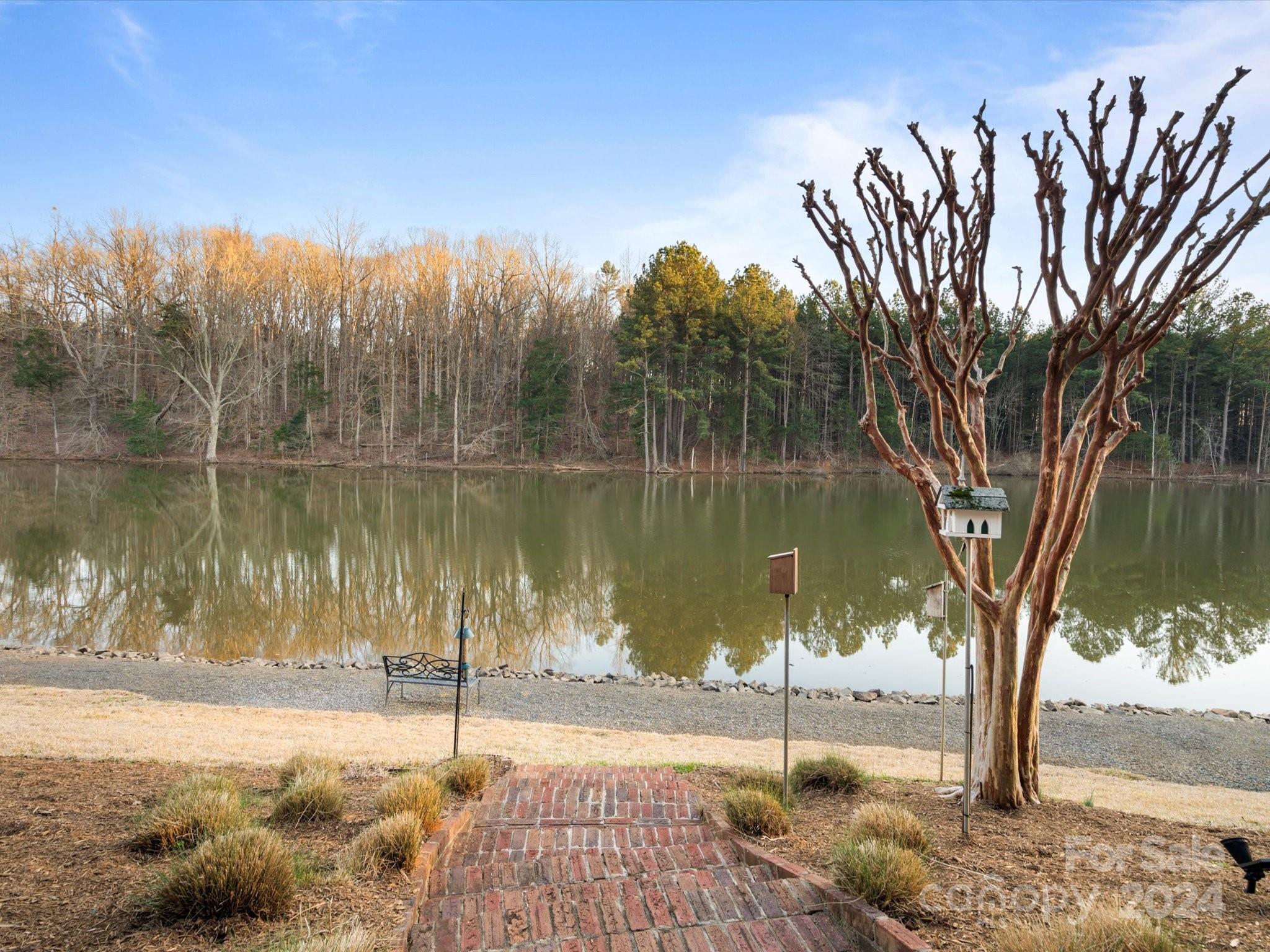 135 Spring Branch Road Fort Mill, SC 29715 - Photo 42 of 48 a lake view with a bench next to a lake