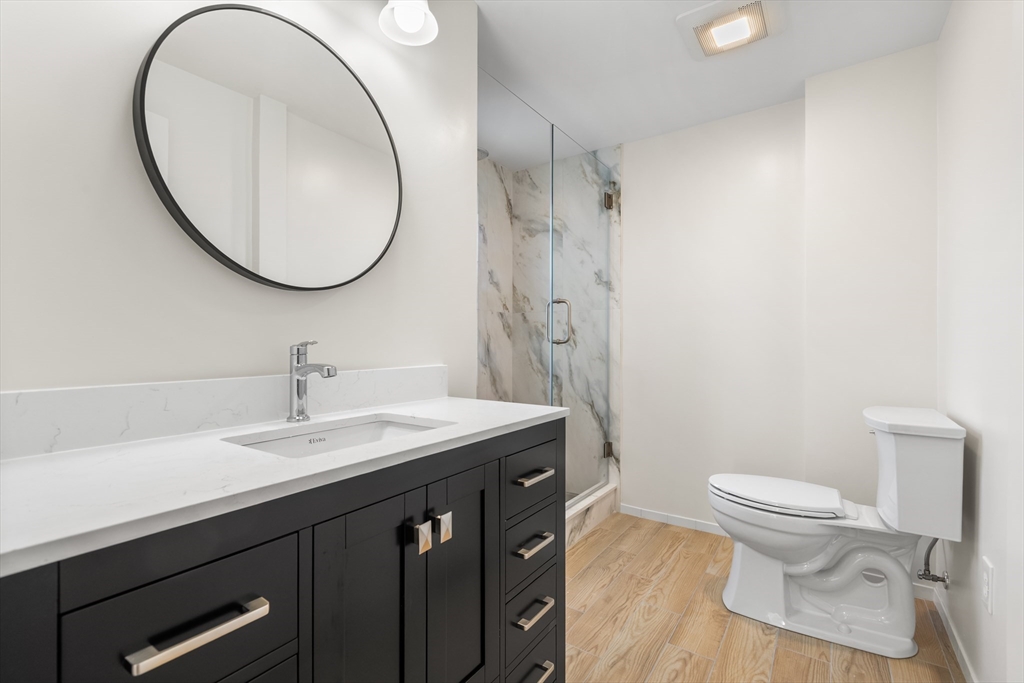 12 Viden Road Quincy, MA 02169 - Photo 9 of 29 a bathroom with a granite countertop toilet a sink and a mirror