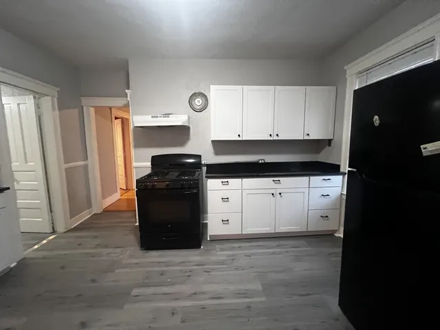 a kitchen with a refrigerator and a stove top oven