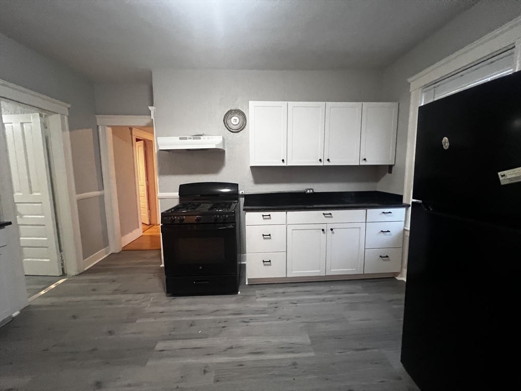 55 Vernon Street, Unit 2 Worcester, MA 01610 - Photo 2 of 10 a kitchen with a refrigerator and a stove top oven