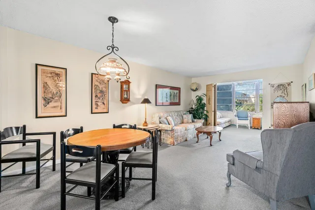 a living room with furniture a dining table and a window