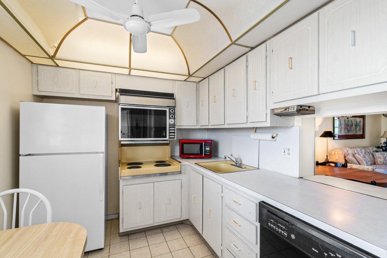 2615 Northeast 3rd Street, Unit 308 Boynton Beach, FL 33435 - Photo 2 of 27 a kitchen with stainless steel appliances a refrigerator sink and cabinets