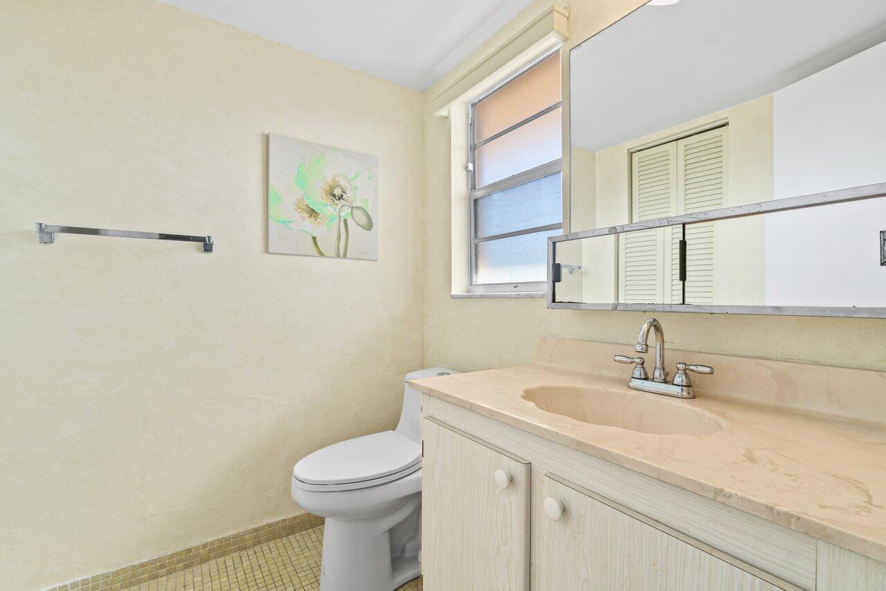 2615 Northeast 3rd Street, Unit 308 Boynton Beach, FL 33435 - Photo 21 of 27 a bathroom with a sink a toilet and mirror
