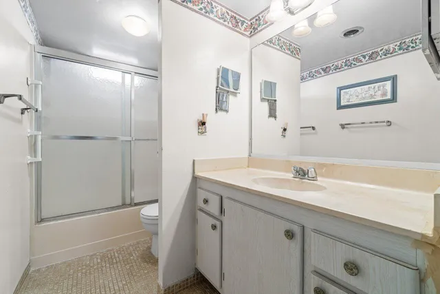 a bathroom with a granite countertop sink a mirror and a shower