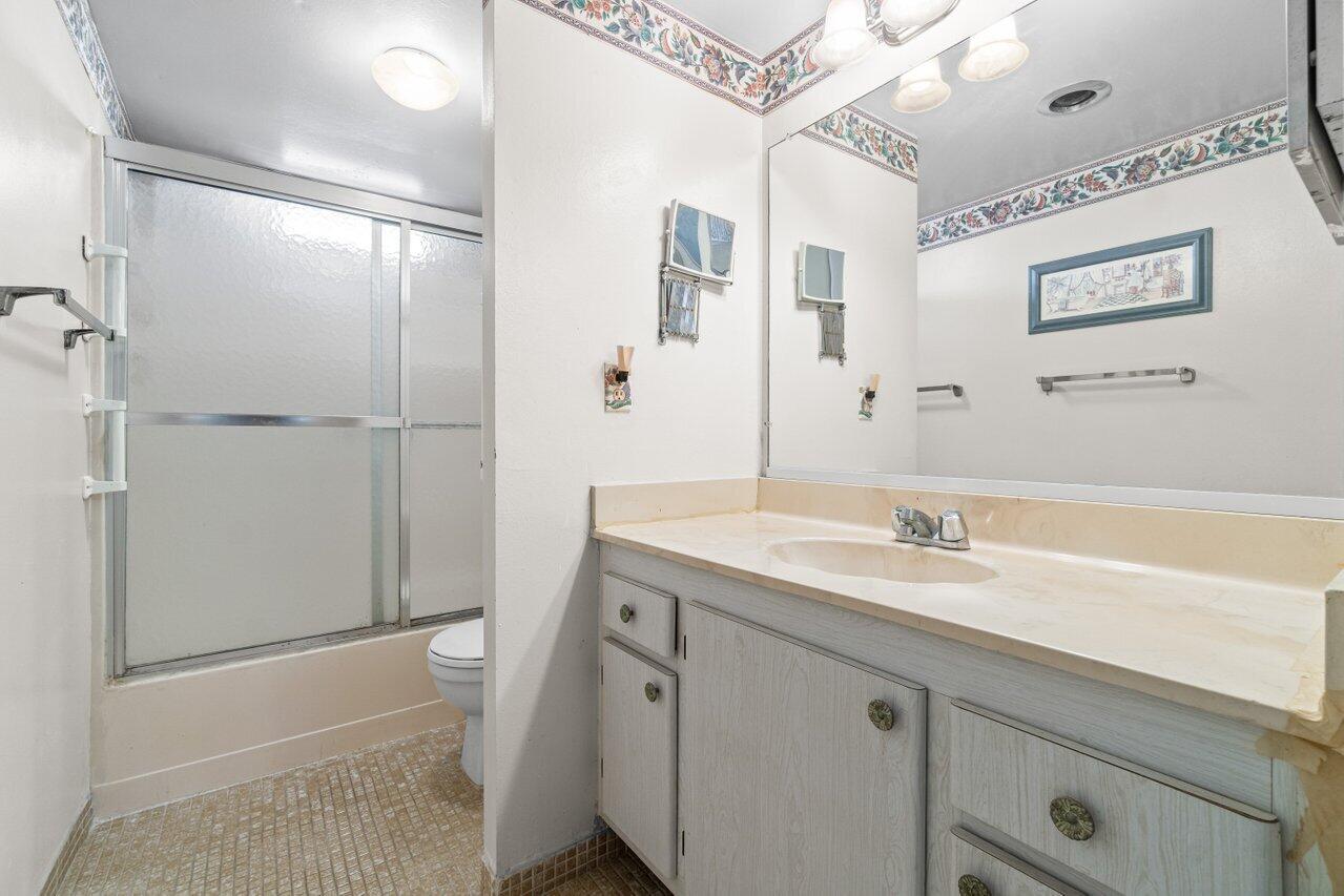2615 Northeast 3rd Street, Unit 308 Boynton Beach, FL 33435 - Photo 8 of 27 a bathroom with a granite countertop sink a mirror and a shower