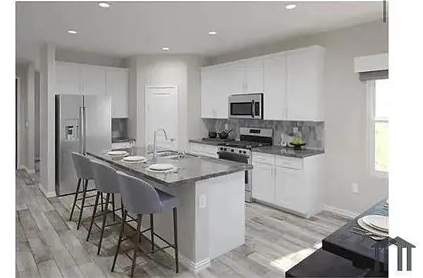 1858 McCree Street Forney, TX 75126 - Photo 4 of 5 Kitchen with a breakfast bar, stainless steel appliances, a center island with sink, white cabinetry, and recessed lighting