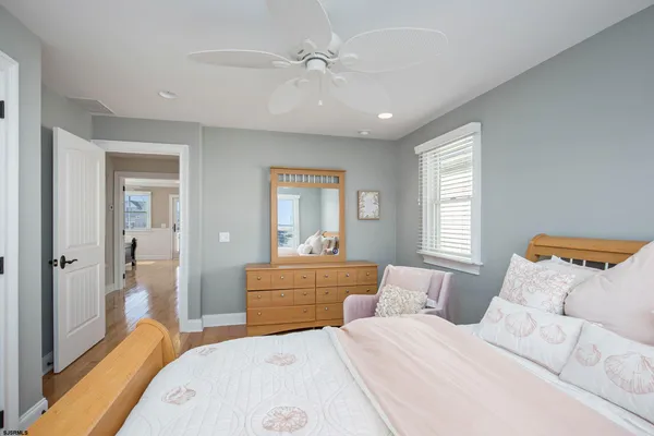 a bedroom with a bed and a chandelier fan
