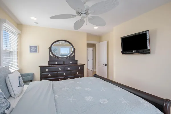 a bedroom with a bed a mirror and a flat screen tv