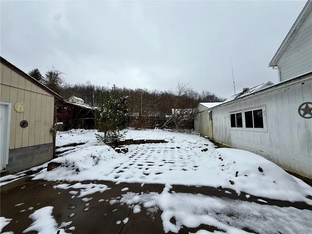 a view of a white house with snow on the road