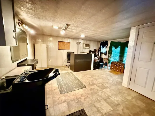 a living room with stainless steel appliances kitchen island granite countertop furniture a refrigerator and a sink
