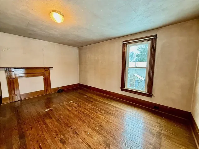 a bedroom with a large bed and dresser with mirror