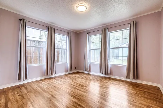 a view of a livingroom with wooden floor and windows