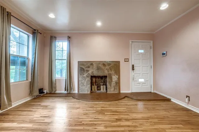 a view of empty room with wooden floor and fireplace