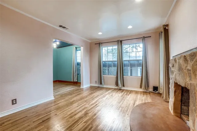 wooden floor and windows in a room with a fireplace