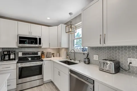 a kitchen with appliances a sink and cabinets