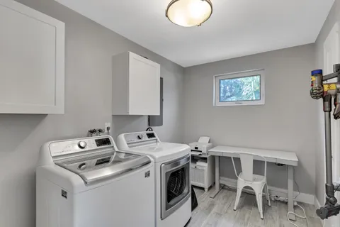 a utility room with dryer washer and a view of living room