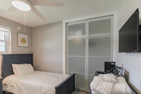 a bedroom with a bed and a flat tv screen on the dresser