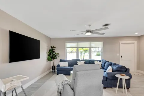 a living room with furniture a flat screen tv and a window