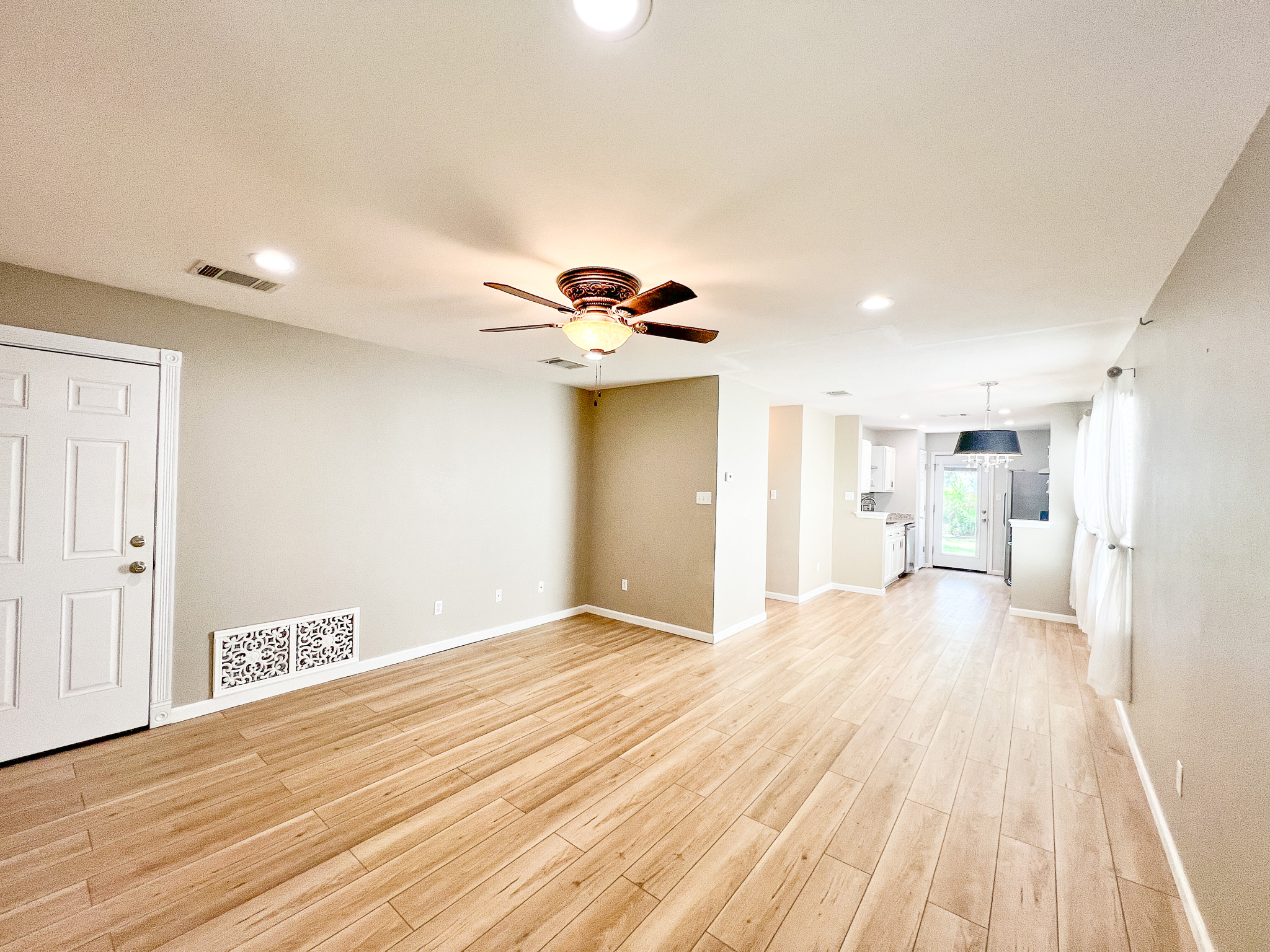 298 Jack Rabbit Lane Buda, TX 78610 - Photo 24 of 24 An open floorplan living area flows seamlessly into the kitchen, featuring modern recessed lighting and a ceiling fan.