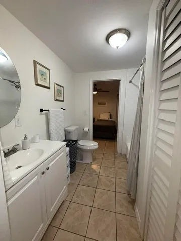 a view of a hallway with a livingroom and a bathroom with sink