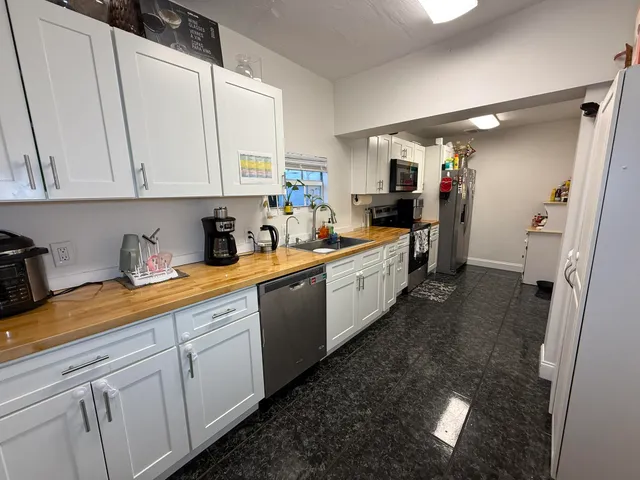a view of kitchen and sink with wooden cabinets