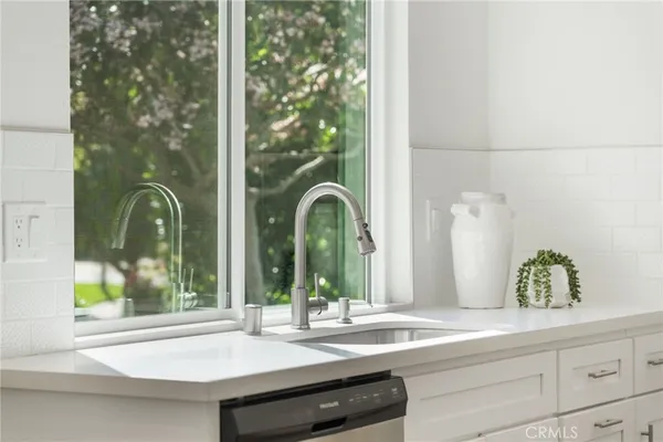 a bathroom with a granite countertop sink and mirror with large window