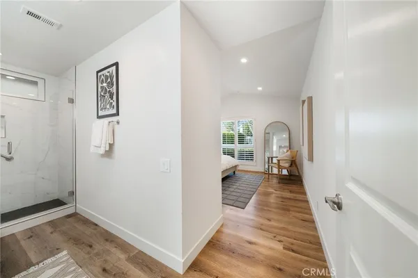 a view of a hallway with wooden floor and a living room