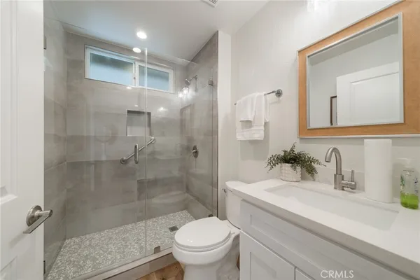 a bathroom with a sink a toilet and shower