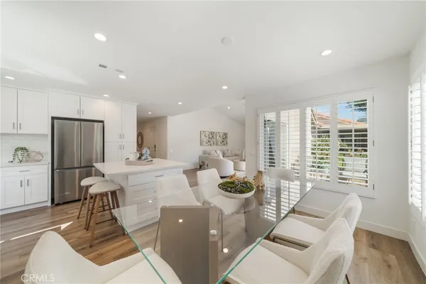 a view of a dining room with furniture a kitchen and chandelier