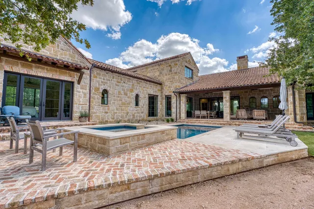 a view of house with swimming pool and sitting area