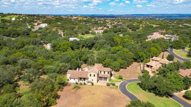 an aerial view of residential house with outdoor space and trees all around