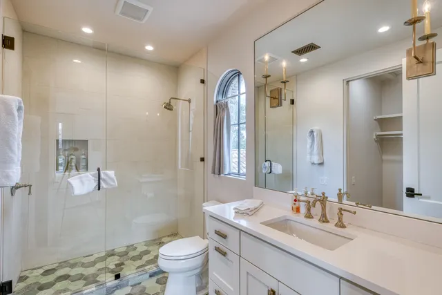 a bathroom with a granite countertop sink toilet and shower
