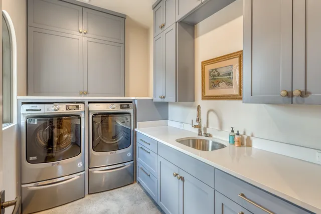 a utility room with sink dryer and washer