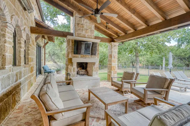 a outdoor space with patio the couches and a fireplace with the potted plants