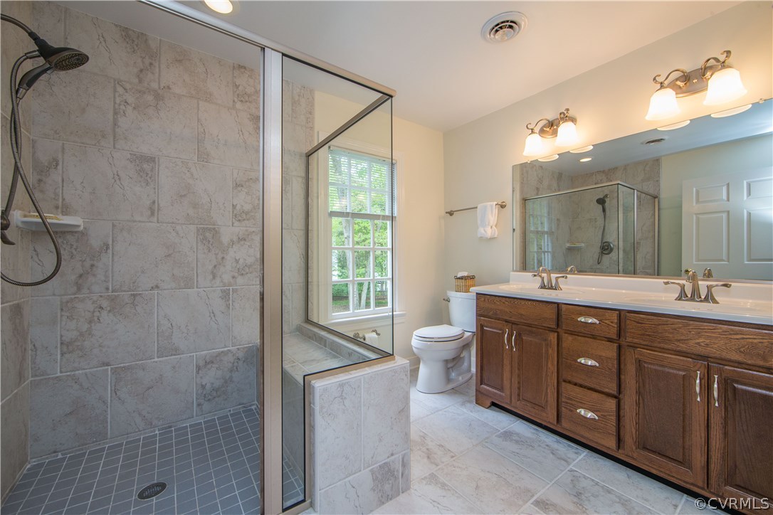 2701 East Brigstock Road Midlothian, VA 23113 - Photo 31 of 50 a spacious bathroom with a granite countertop sink toilet a large mirror and shower