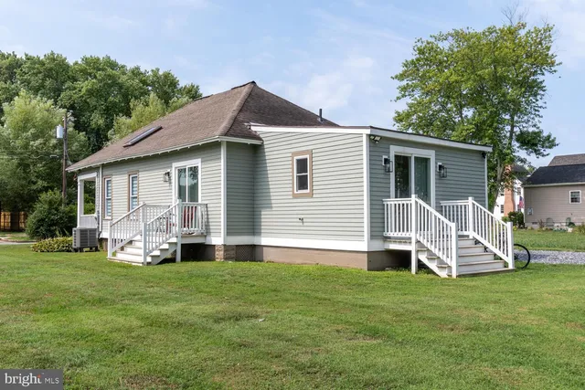 a view of a house with a yard and sitting area