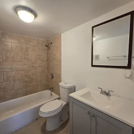 a bathroom with a toilet a sink a mirror and bathtub